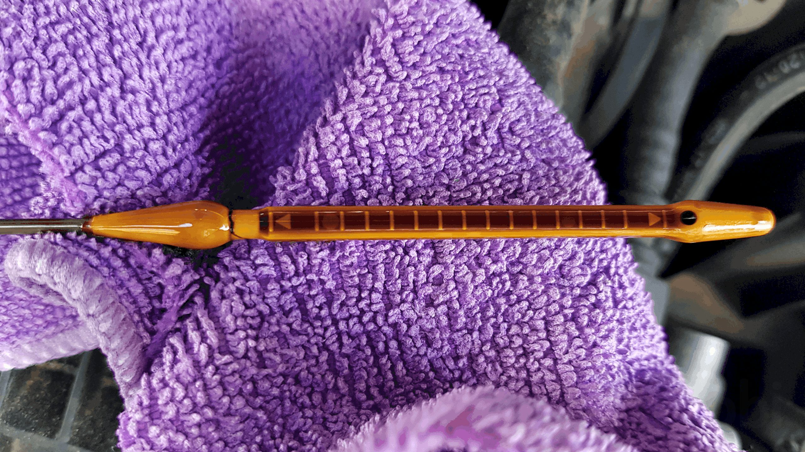 Oil dipstick before it has been wiped off showing an inaccurate reading.